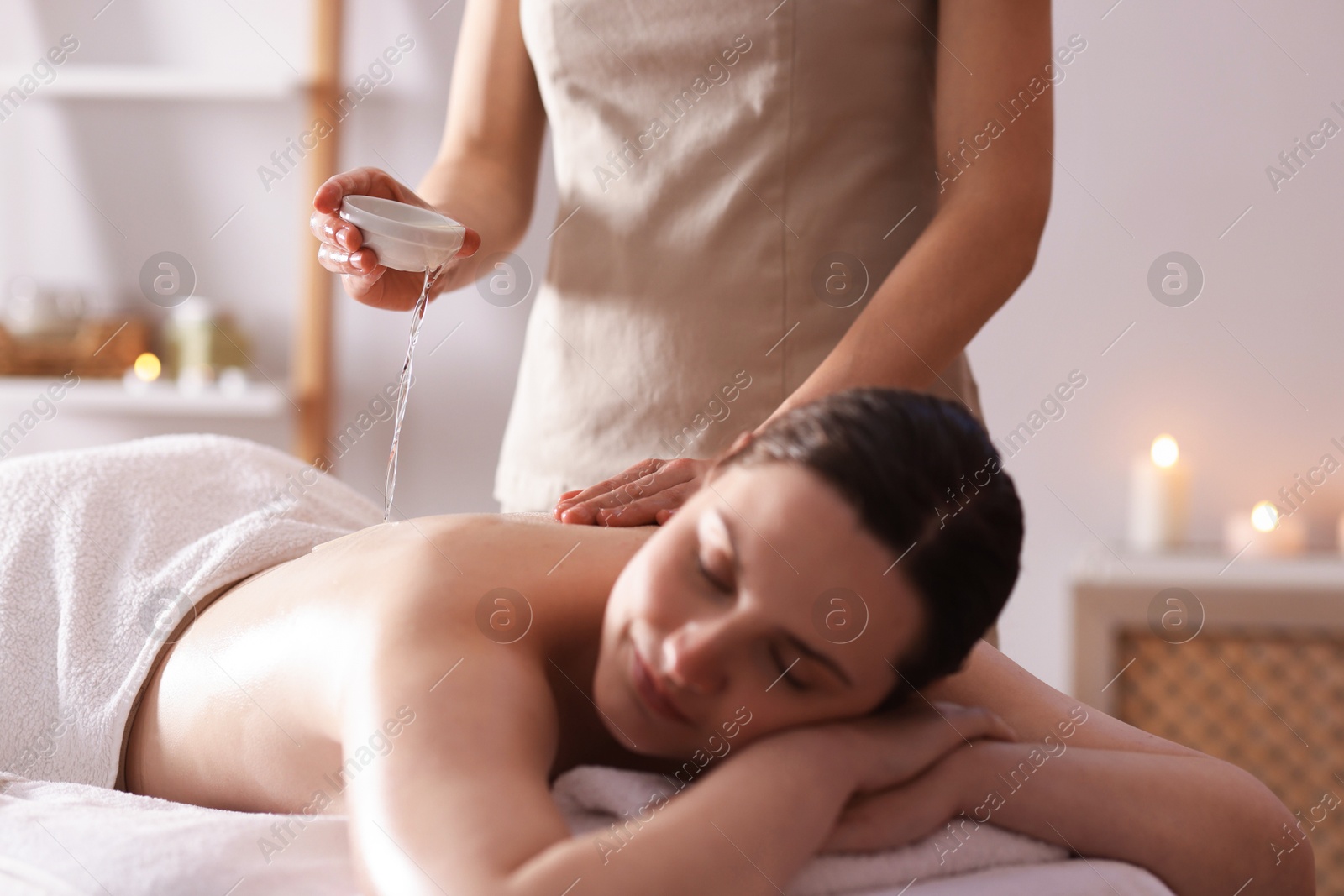 Woman receiving back massage with oil in spa salon Photo of Woman receiving back massage with oil in spa salon