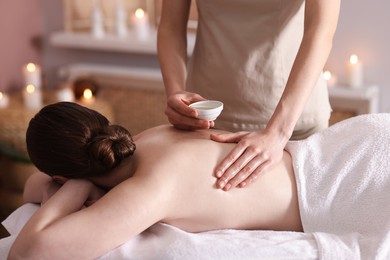 Photo of Woman receiving back massage with oil in spa salon