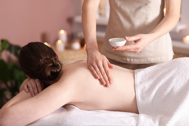 Photo of Woman receiving back massage with oil in spa salon