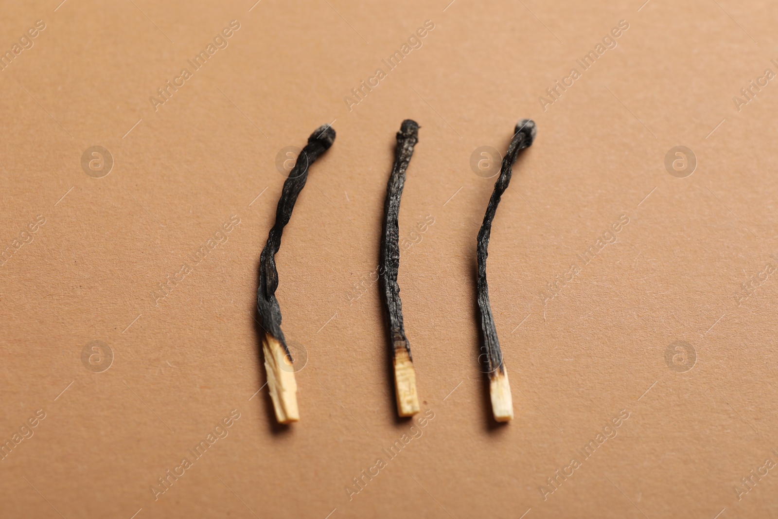 Burnt matches on beige background, closeup view Photo of Burnt matches on beige background, closeup view