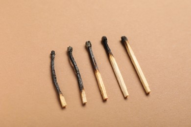 Photo of Burnt matches on beige background, above view