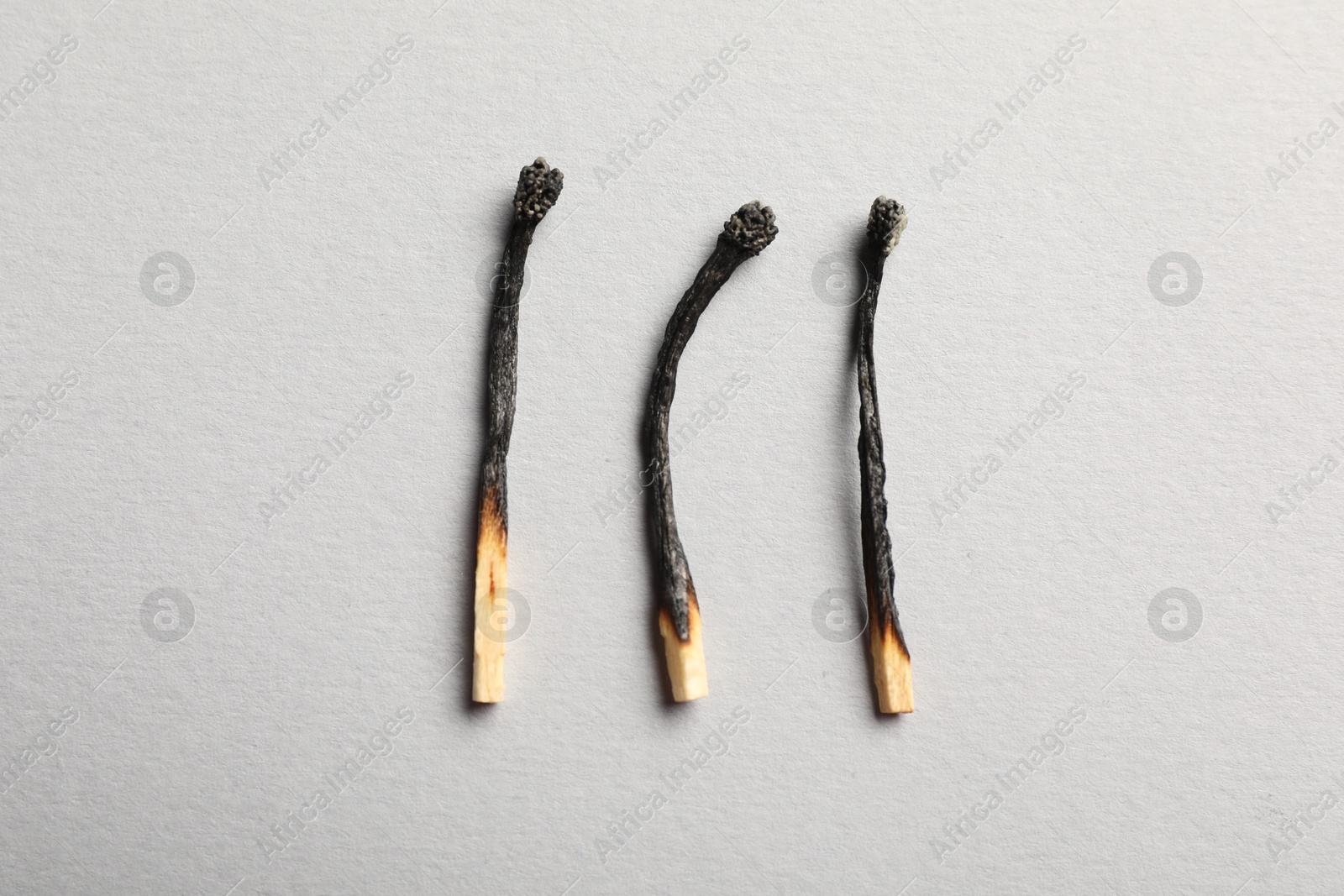 Photo of Burnt matches on grey background, flat lay