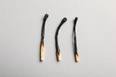 Photo of Burnt matches on grey background, flat lay