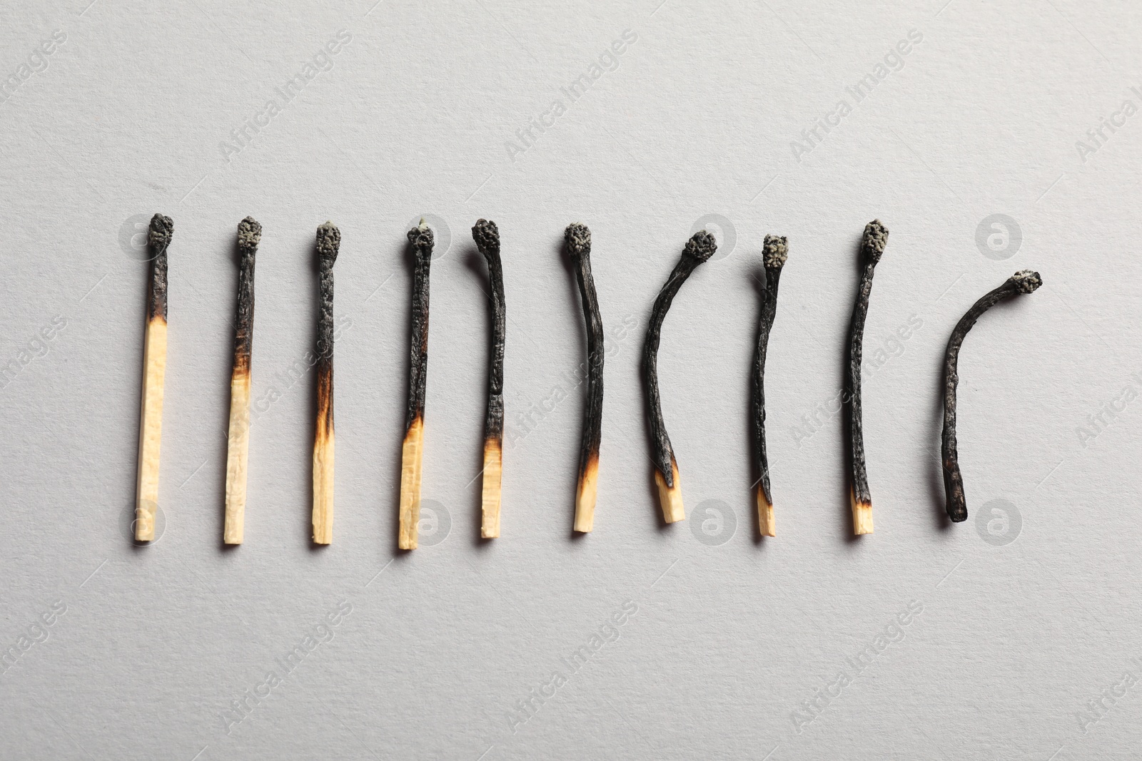 Photo of Burnt matches on grey background, flat lay