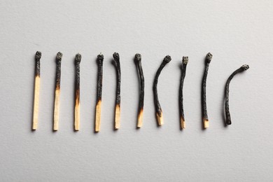 Photo of Burnt matches on grey background, flat lay