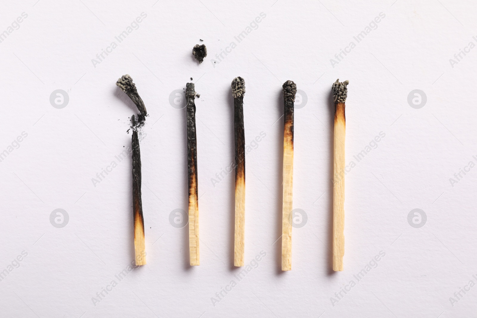 Photo of Burnt matches on light grey background, flat lay