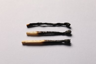 Photo of Burnt matches on grey background, closeup view