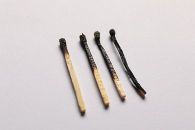 Photo of Burnt matches on grey background, closeup view