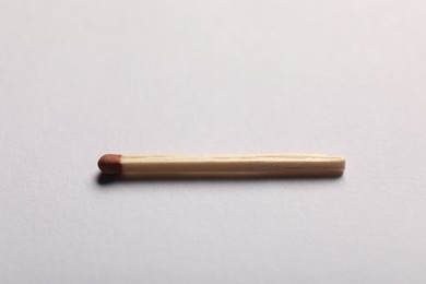 Photo of One match with brown head on grey background, closeup