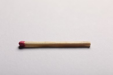 Photo of One match with pink head on grey background, closeup