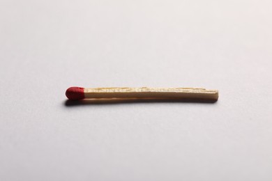 Photo of One match with red head on grey background, closeup