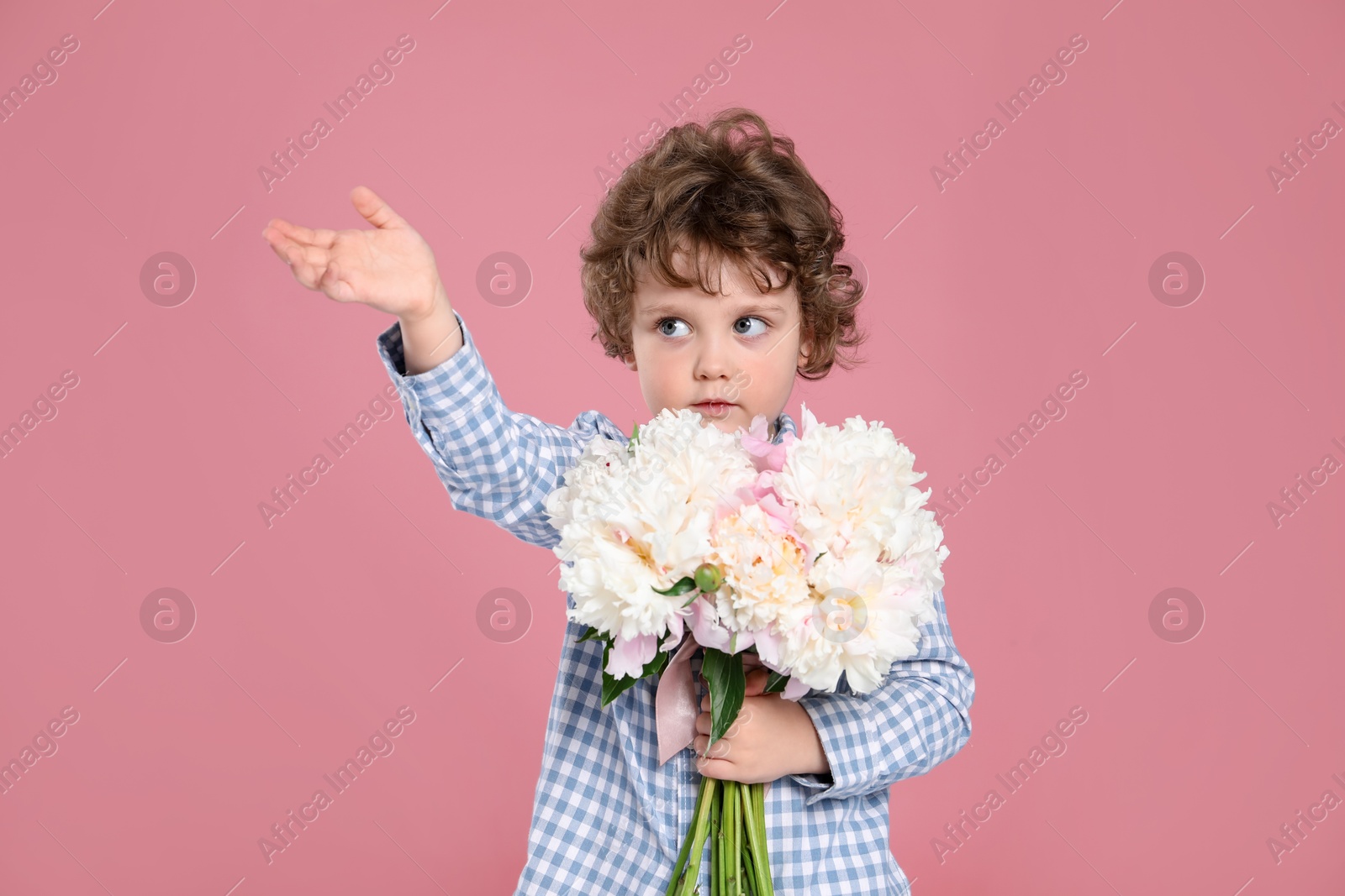 Cute little boy with bouquet of beautiful peonies on pink background Photo of Cute little boy with bouquet of beautiful peonies on pink background