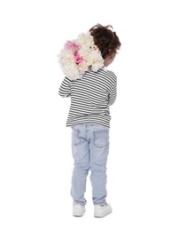 Photo of Cute little boy with bouquet of beautiful peonies on white background, back view