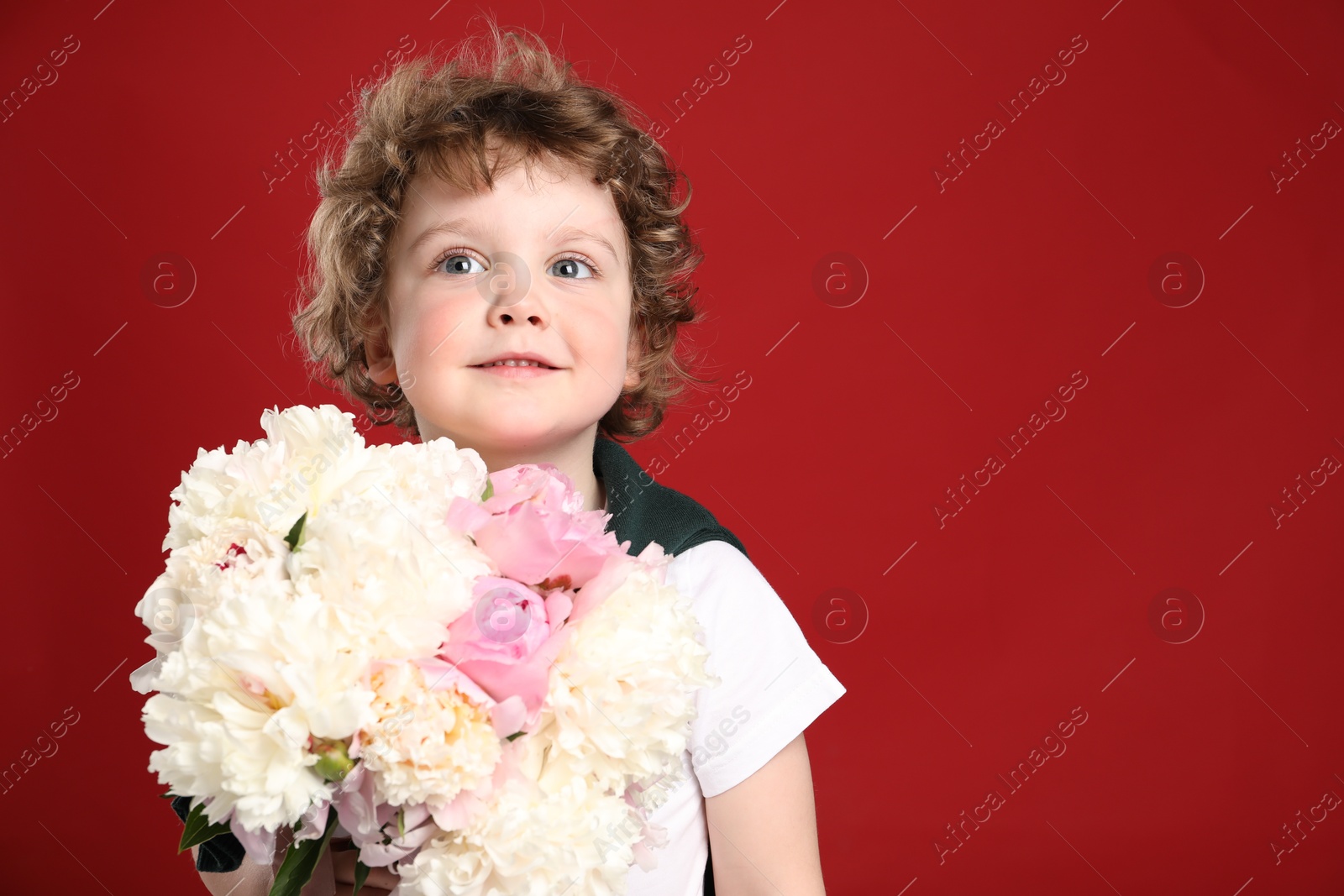 Cute little boy with bouquet of beautiful peonies on red background. Space for text Photo of Cute little boy with bouquet of beautiful peonies on red background. Space for text