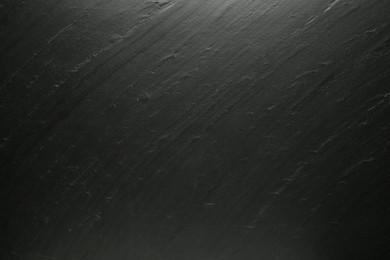 Photo of Black textured surface as background, closeup view