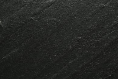 Photo of Black textured surface as background, closeup view