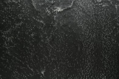 Photo of Black textured surface as background, closeup view