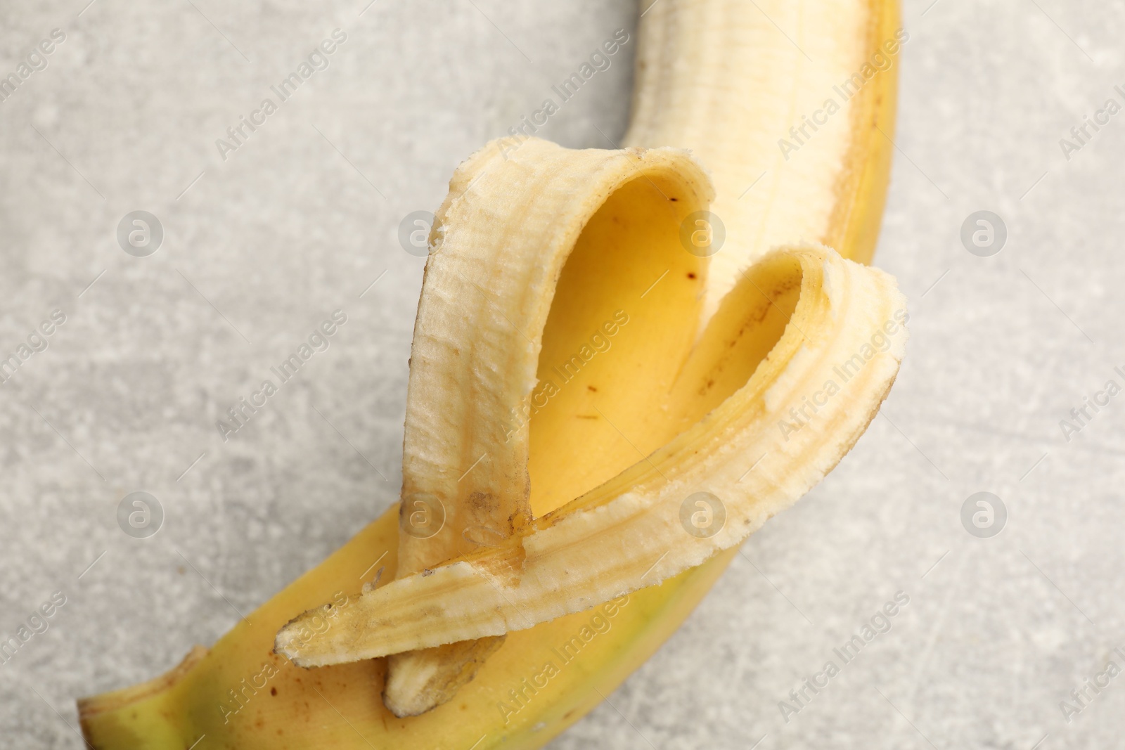 Banana with heart made of peel on grey table, above view Photo of Banana with heart made of peel on grey table, above view