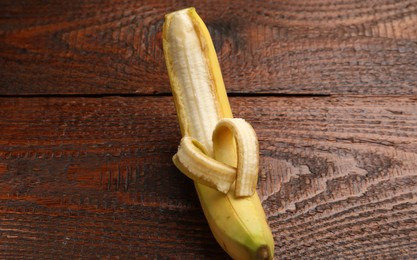 Photo of Banana with heart made of peel on wooden table, above view