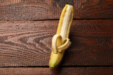 Photo of Banana with heart made of peel on wooden table, top view