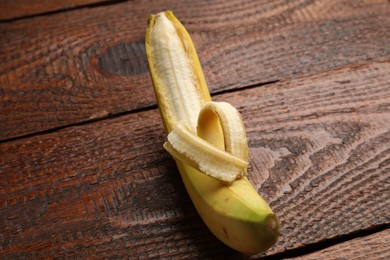 Photo of Banana with heart made of peel on wooden table, above view