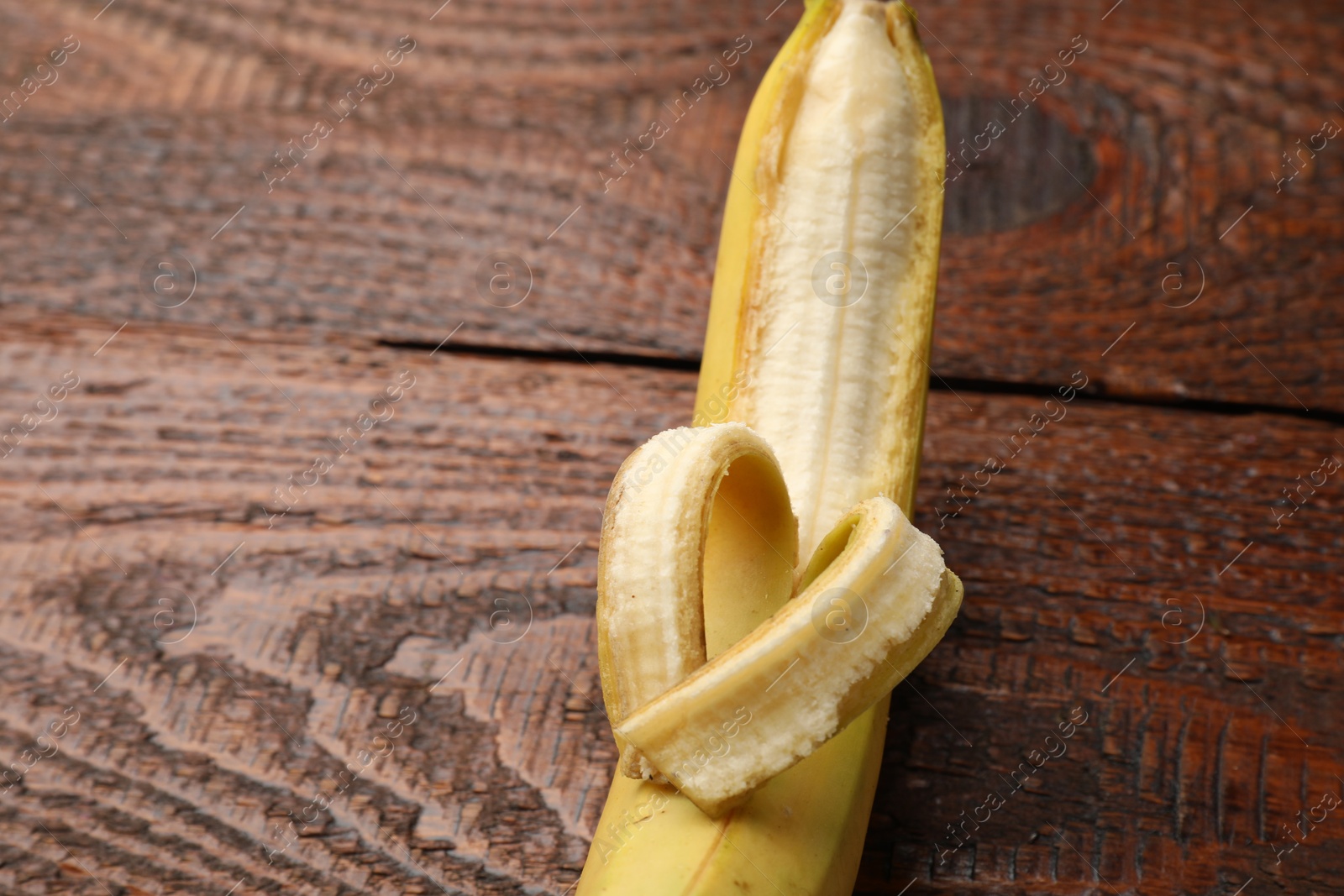 Banana with heart made of peel on wooden table, above view Photo of Banana with heart made of peel on wooden table, above view