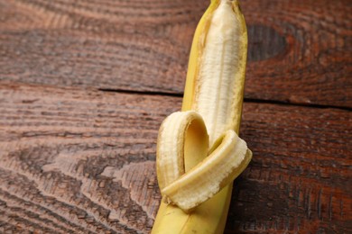 Photo of Banana with heart made of peel on wooden table, above view