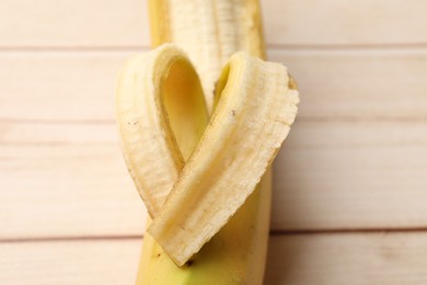 Photo of Banana with heart made of peel on wooden table, closeup