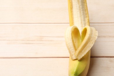 Photo of Banana with heart made of peel on wooden table, above view. Space for text