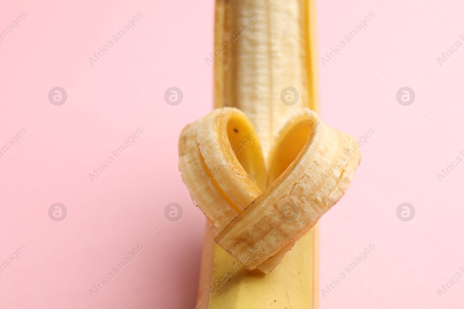 Banana with heart made of peel on pink background, closeup. Space for text Photo of Banana with heart made of peel on pink background, closeup. Space for text