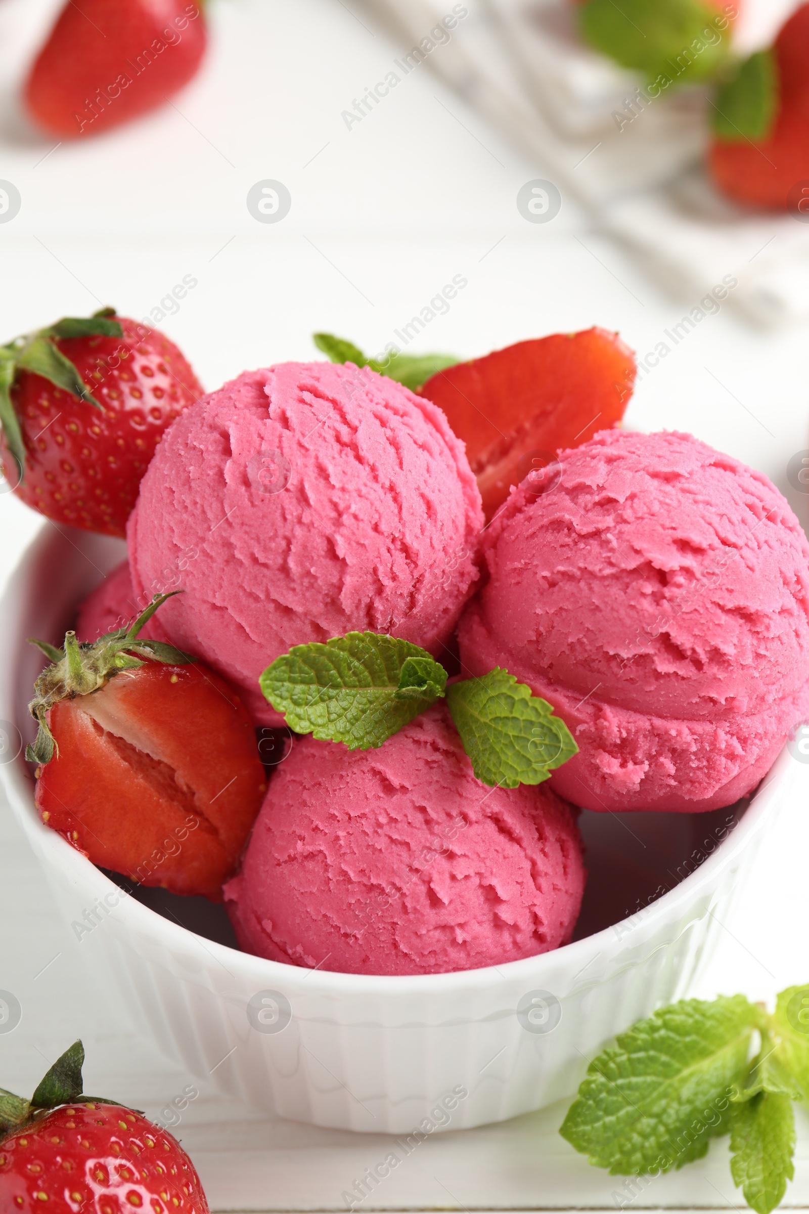 Photo of Tasty sorbet with strawberries and mint served on white wooden table, closeup