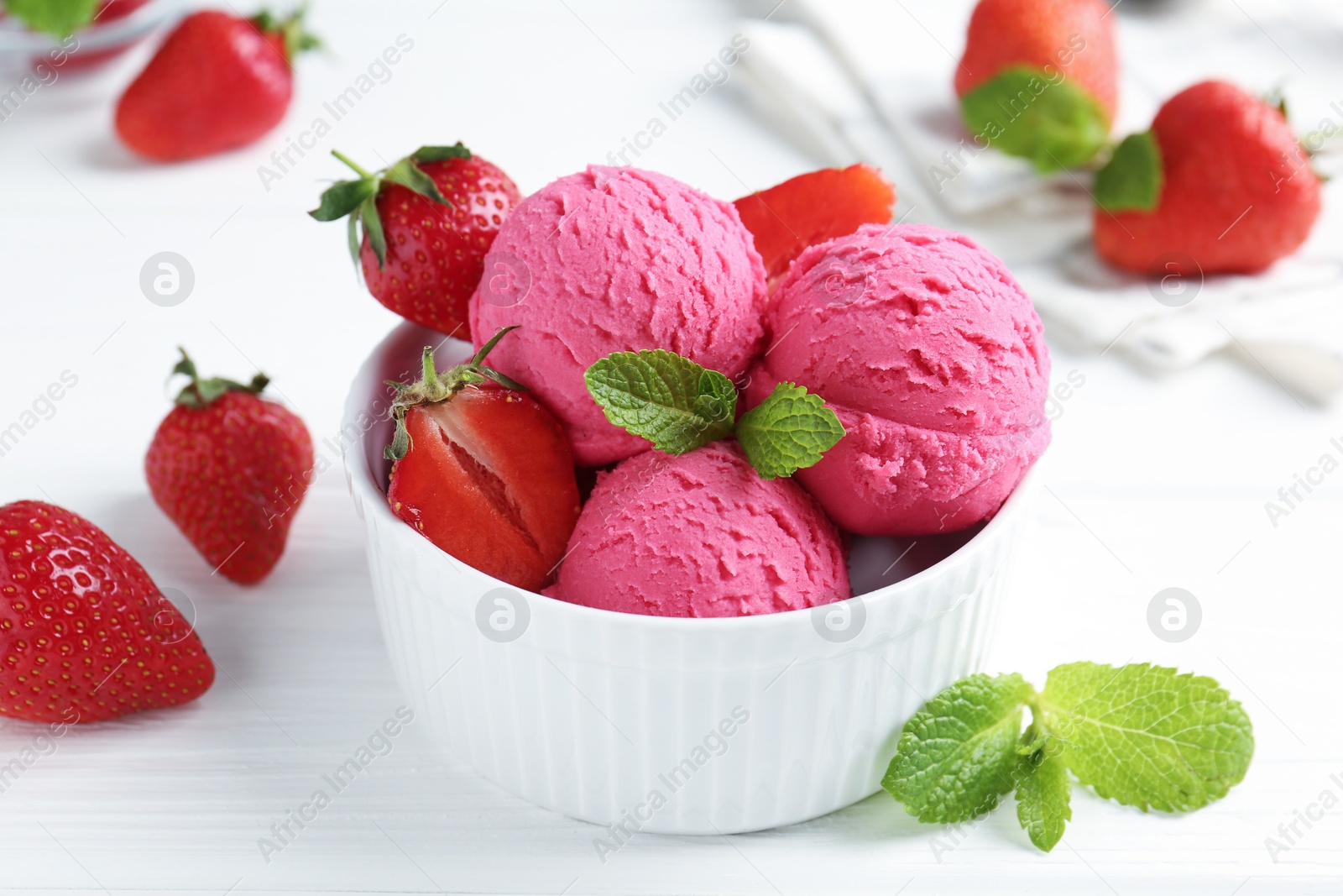 Tasty sorbet with strawberries and mint served on white wooden table, closeup Photo of Tasty sorbet with strawberries and mint served on white wooden table, closeup