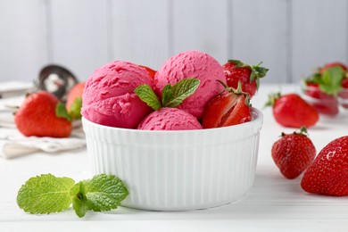 Photo of Tasty sorbet with strawberries and mint served on white wooden table, closeup