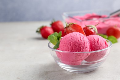 Photo of Tasty sorbet with strawberries and mint served on light table, closeup. Space for text