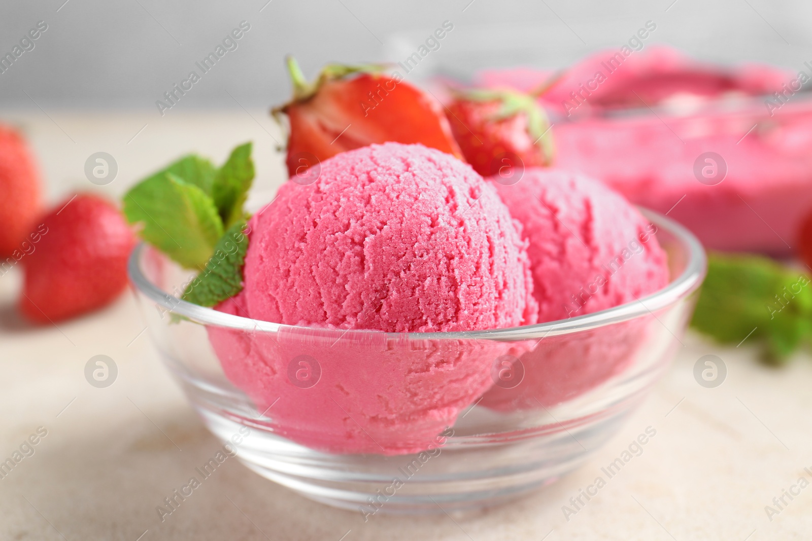 Photo of Tasty sorbet with strawberries and mint served on light table, closeup