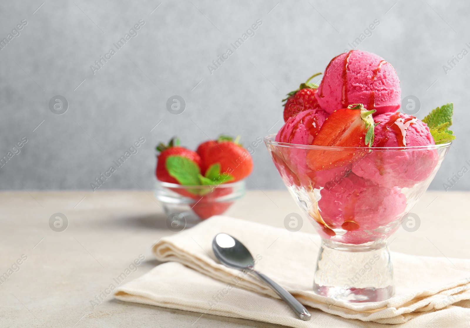 Photo of Tasty sorbet with strawberries and mint served on light table, closeup. Space for text