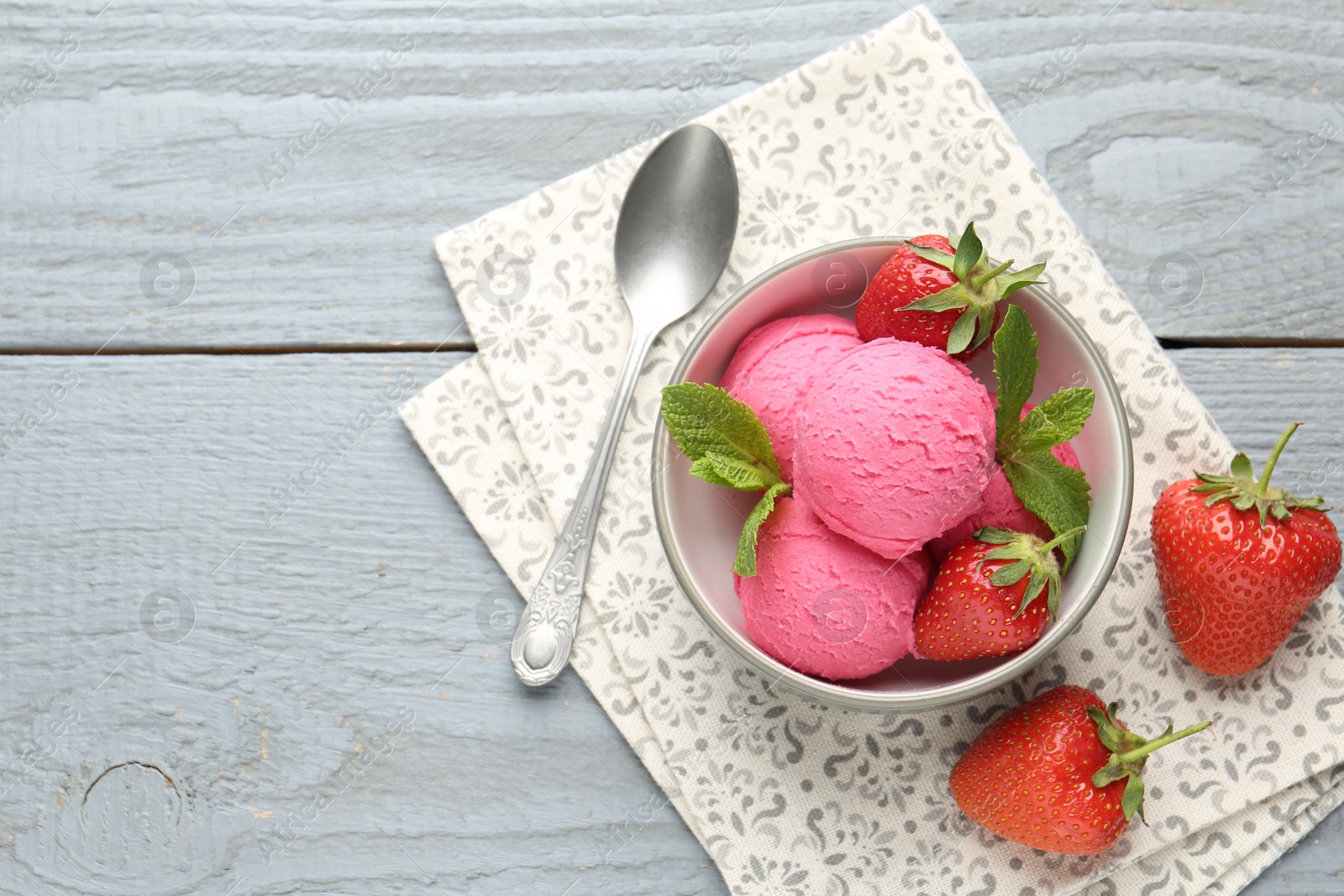 Photo of Tasty sorbet with strawberries and mint served on grey wooden table, flat lay. Space for text
