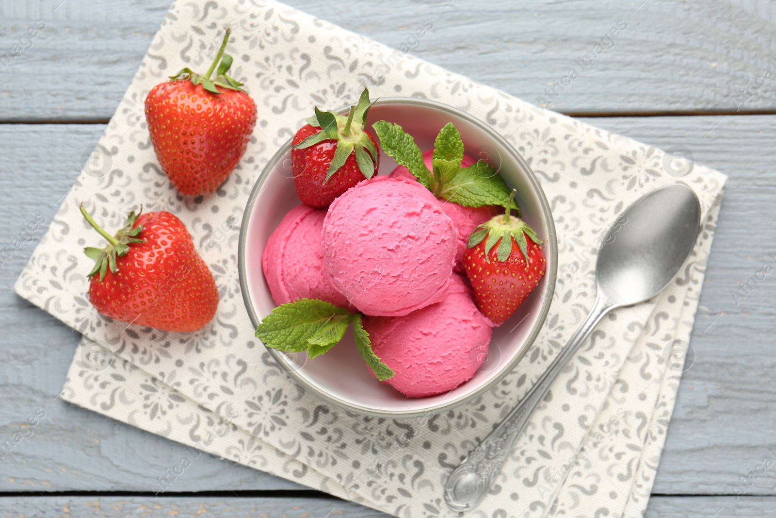 Tasty sorbet with strawberries and mint served on grey wooden table, flat lay Photo of Tasty sorbet with strawberries and mint served on grey wooden table, flat lay