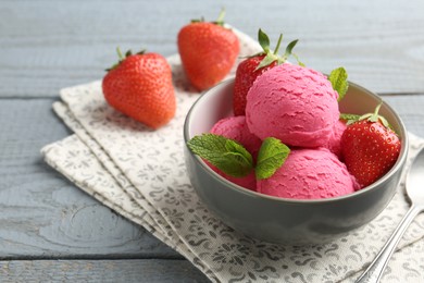 Photo of Tasty sorbet with strawberries and mint served on grey wooden table, closeup