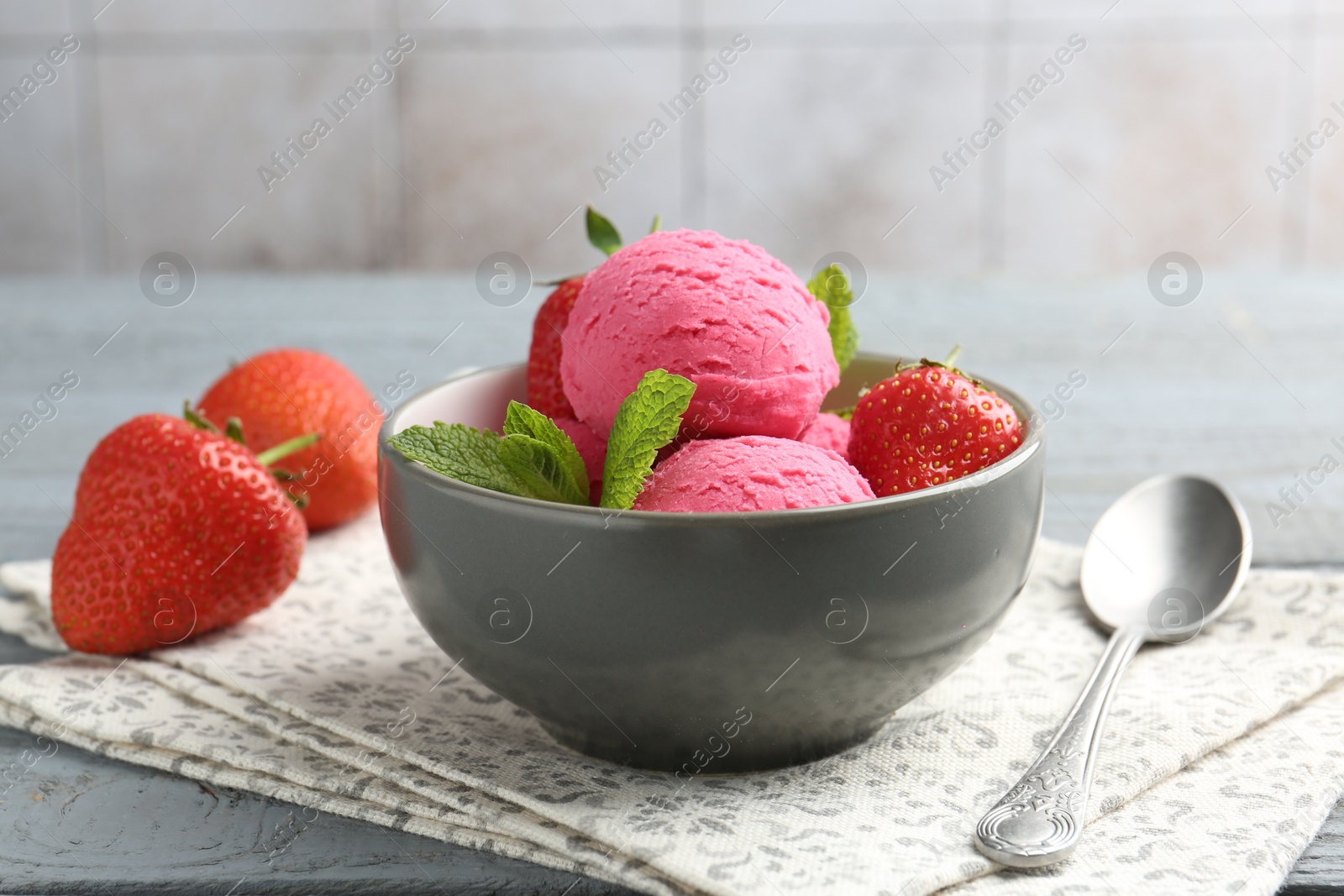 Tasty sorbet with strawberries and mint served on grey wooden table, closeup Photo of Tasty sorbet with strawberries and mint served on grey wooden table, closeup