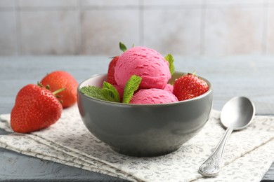 Photo of Tasty sorbet with strawberries and mint served on grey wooden table, closeup