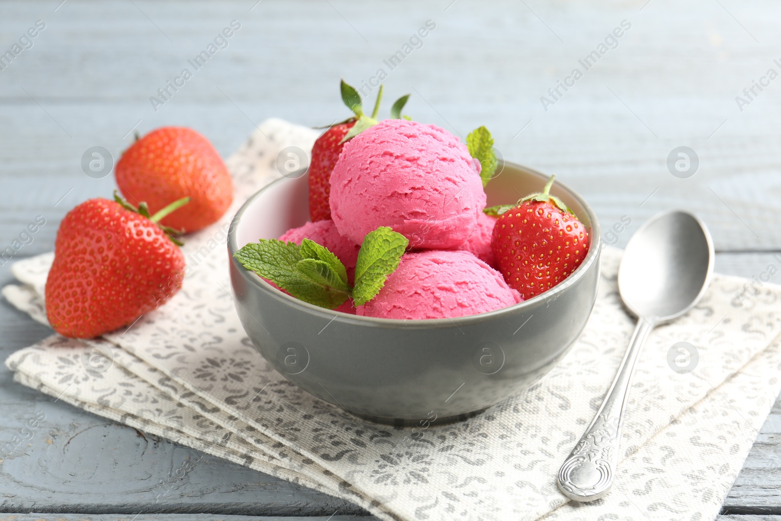 Tasty sorbet with strawberries and mint served on grey wooden table, closeup Photo of Tasty sorbet with strawberries and mint served on grey wooden table, closeup