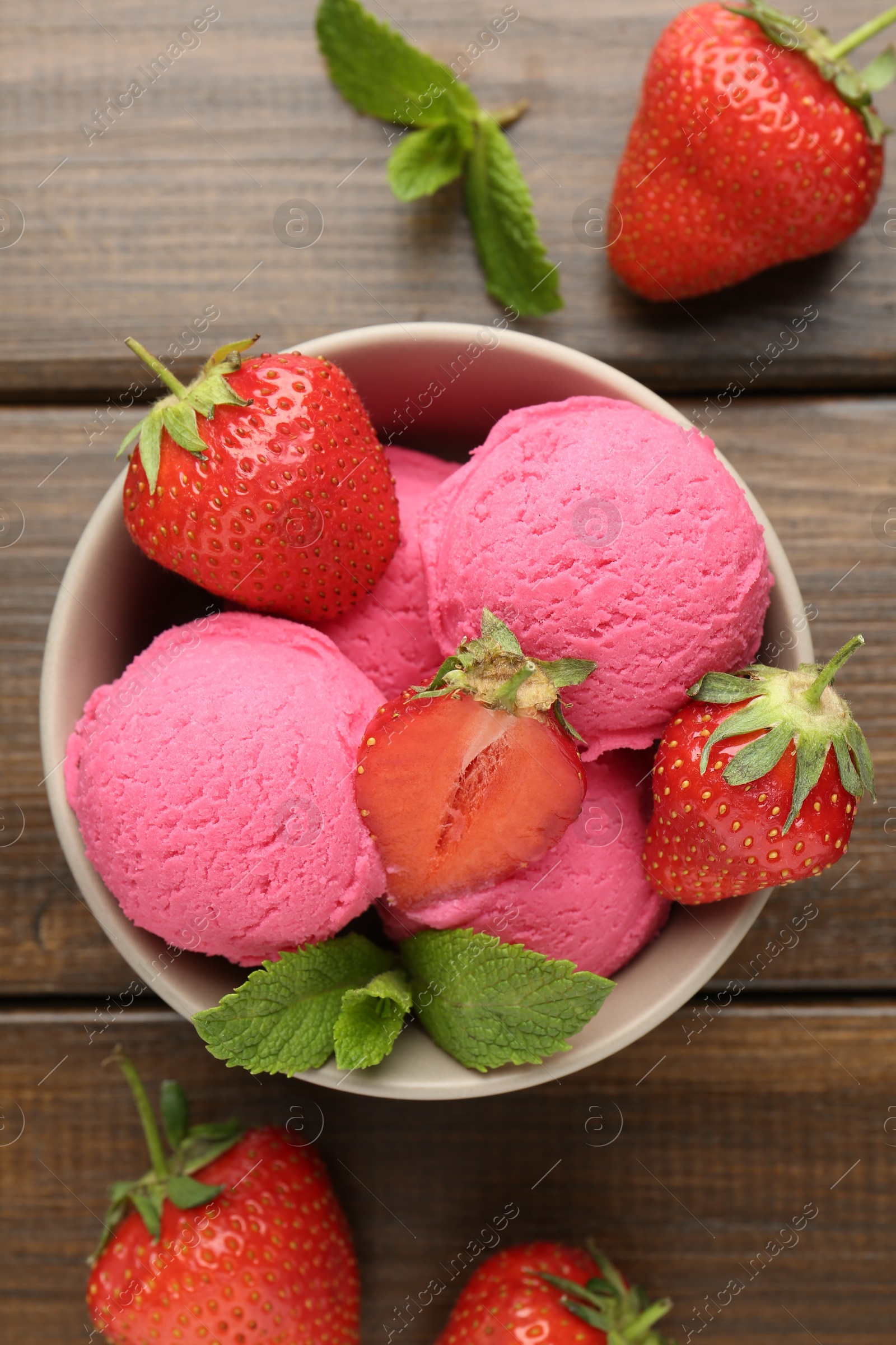 Photo of Tasty sorbet with strawberries and mint served on wooden table, flat lay