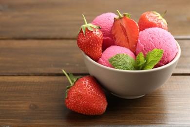 Photo of Tasty sorbet with strawberries and mint served on wooden table, closeup. Space for text