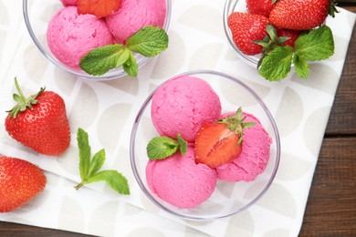 Photo of Tasty sorbet with strawberries and mint served on wooden table, flat lay