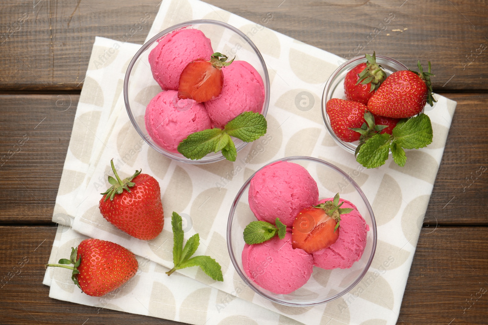 Tasty sorbet with strawberries and mint served on wooden table, flat lay Photo of Tasty sorbet with strawberries and mint served on wooden table, flat lay