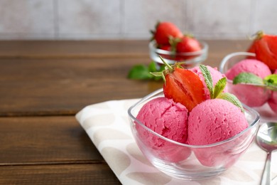 Photo of Tasty sorbet with strawberries and mint served on wooden table, closeup. Space for text
