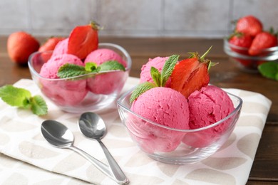 Photo of Tasty sorbet with strawberries and mint served on wooden table, closeup
