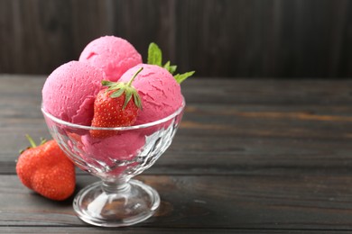 Photo of Tasty sorbet with strawberries and mint served on wooden table, closeup. Space for text