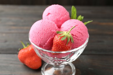 Photo of Tasty sorbet with strawberries and mint served on wooden table, closeup